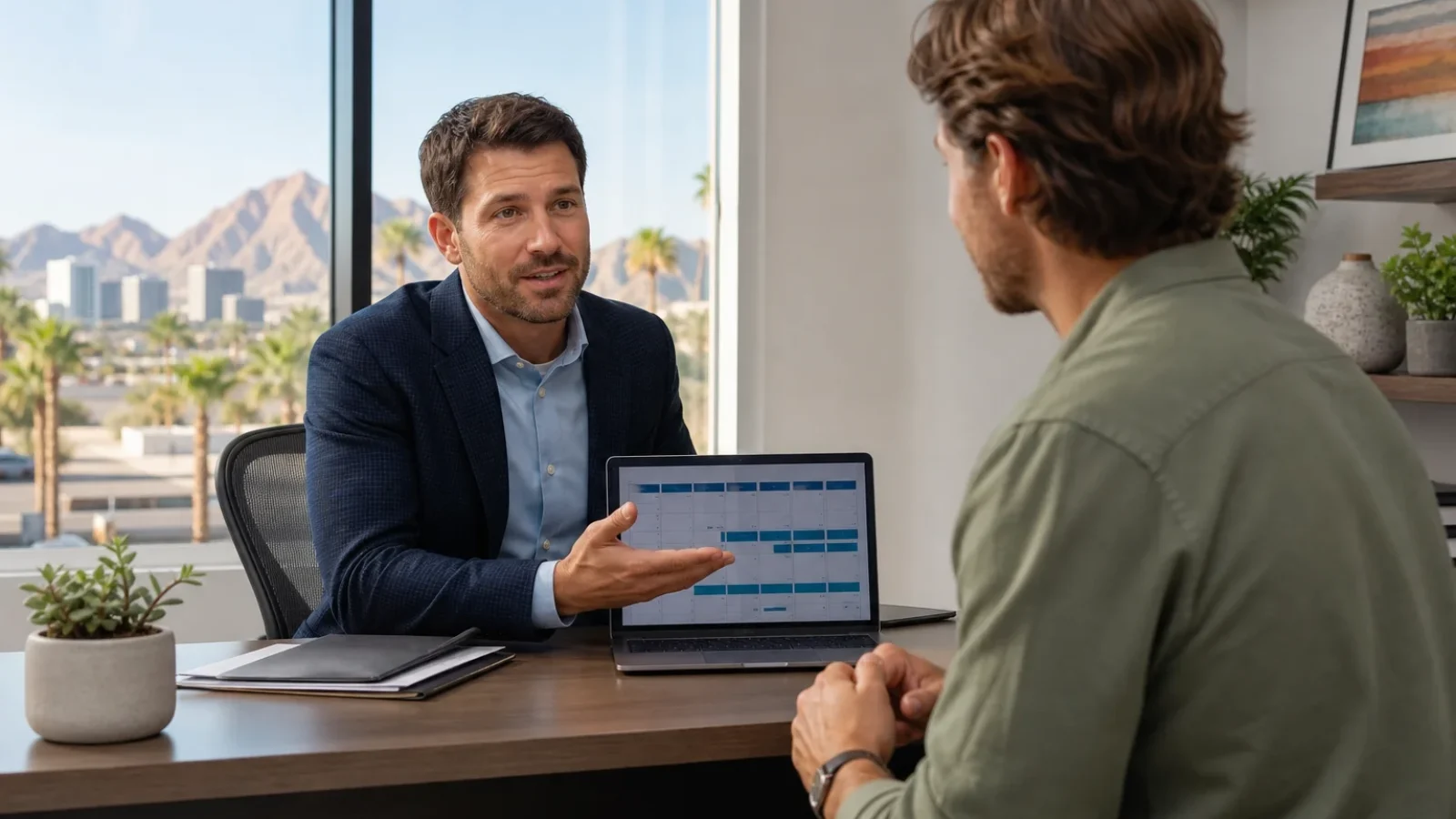 Health insurance advisor explaining short-term health insurance in Arizona to a client at a modern office desk
